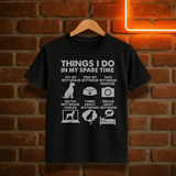 Black t-shirt with white text and graphics on a hanger against a brick wall background