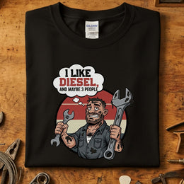 I Like Diesel & Maybe 3 People T-Skjorte design with a mechanic holding wrenches on a black Gildan shirt.