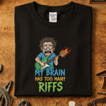 My Brain Has Too Many Riffs T-Skjorte design, featuring a cartoon character playing guitar on a black cotton shirt.