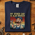 My Other Car Is Also Broken T-Skjorte med en morsom mekaniker illustrasjon, perfekt for bilentusiaster.