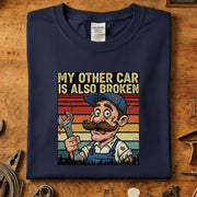 My Other Car Is Also Broken T-Skjorte med en morsom mekaniker illustrasjon, perfekt for bilentusiaster.