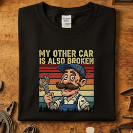 My Other Car Is Also Broken T-Skjorte med morsom illustrasjon av en mekaniker på Gildan 64000.