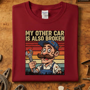 My Other Car Is Also Broken T-Skjorte med vintage verkstedmotiv på rød genser, perfekt for bilentusiasten.