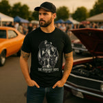 Man wearing The Runaway Boys Est. 2017 T-Skjorte at a car event with vintage cars in the background.